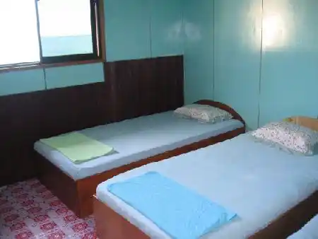 Une chambre simple, propre et abordable pour les plongeurs. Chambre double simple et propre au Mabul Backpackers, un logement confortable et économique dans une longhouse pour les plongeurs à petit budget.