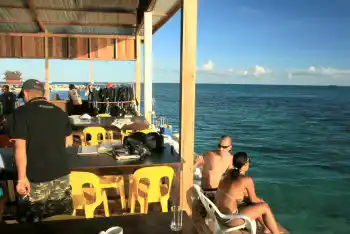 Le lieu idéal pour décompresser après une journée de plongée. Plongeurs et clients se reposent sur la terrasse commune du Mabul Backpackers face à la mer, après une journée d'exploration des récifs de Sipadan.
