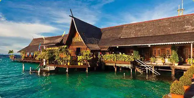 Kapalai Dive Resort's over-water chalets and wooden walkways above the turquoise lagoon.