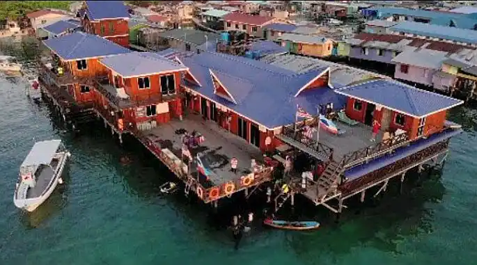 Mabul est le point de départ pour plonger à Sipadan. Vue aérienne par drone du centre de plongée et homestay Big John Scuba, construit sur pilotis au cœur du village des nomades de la mer sur l'île de Mabul.