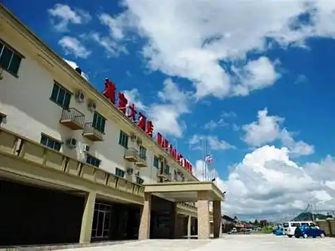 Han Palace Hotel in Semporna under a dramatic blue sky, a mid-range hotel offering comfortable rooms for visitors exploring the Sipadan islands.
