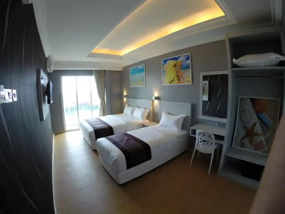 Chambre familiale spacieuse avec vue mer à l'Ocean Inn 3 de Semporna, comprenant deux lits doubles et une décoration moderne pour un séjour économique et confortable.