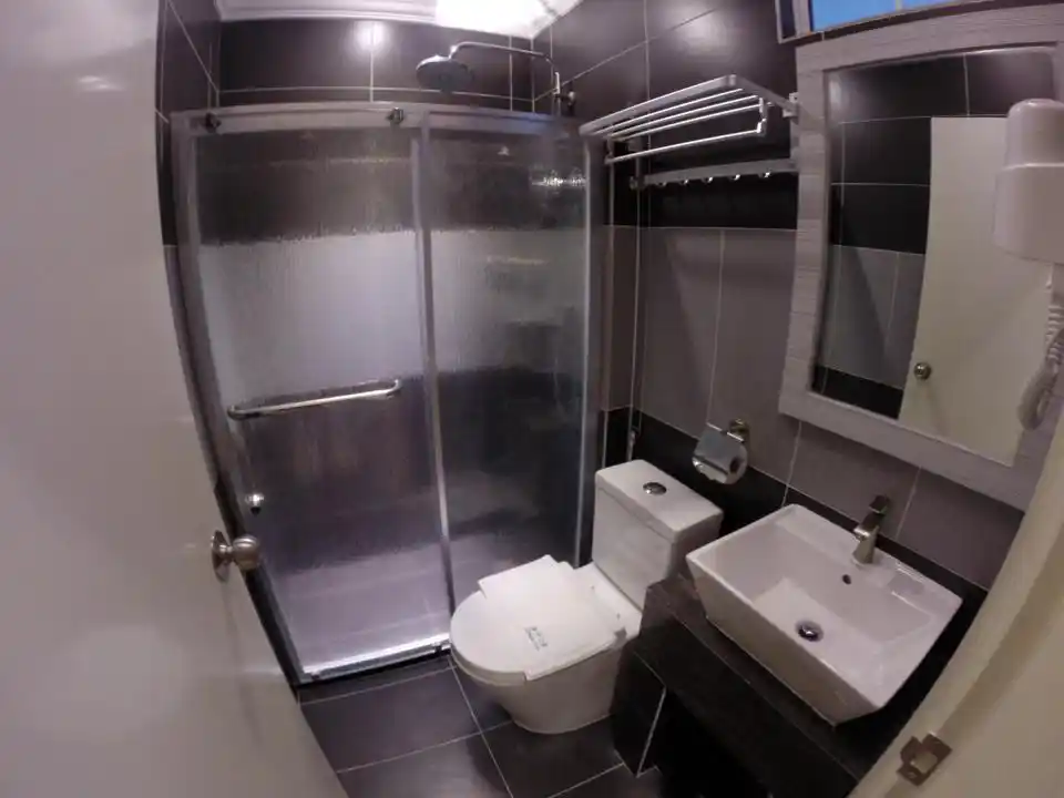 Salle de bain moderne à l'Ocean Inn 3 de Semporna, avec douche vitrée et équipements contemporains.