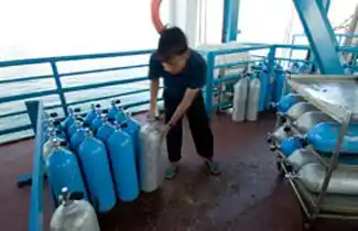 Dive crew at Seaventures Dive Center organizing scuba tanks, ensuring all equipment is ready for the next trip to Sipadan.
