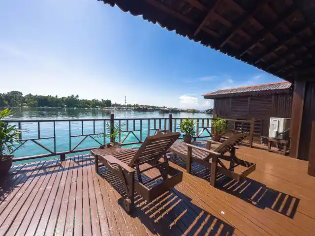 The perfect place to rest after a thrilling dive. Grand Deluxe Cottage deck at Sipadan Water Village, with loungers overlooking the lagoon, is perfect for divers resting after thrilling dives.